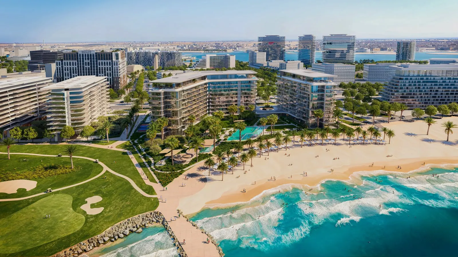 Aerial view along the coast: the golf course and the beach meet in front of the residences, with the Yas Bay skyline behind