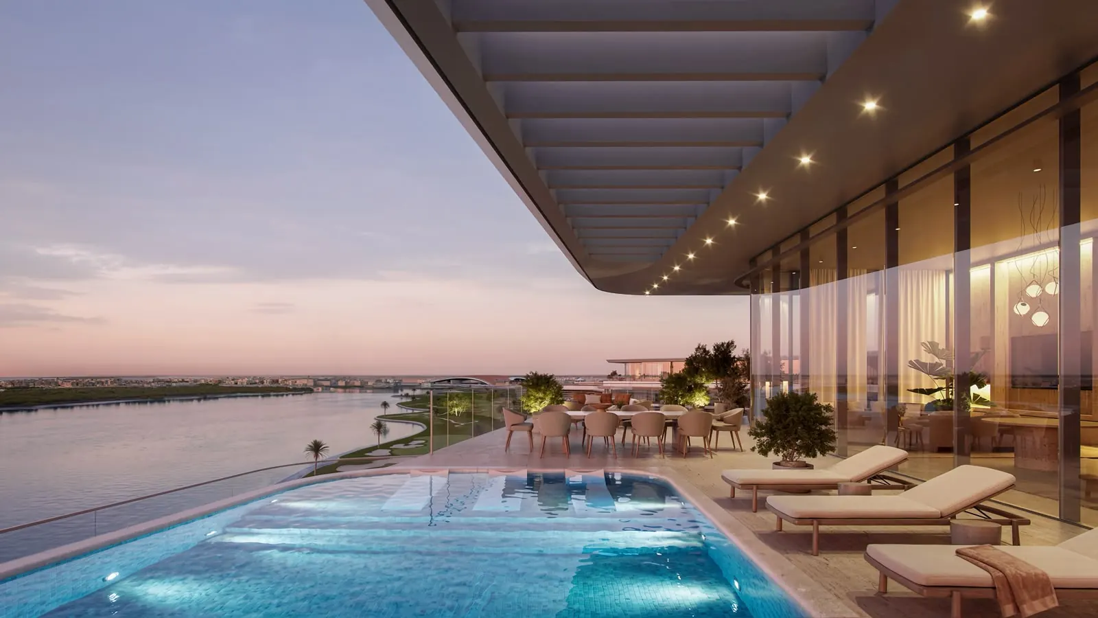 Penthouse terrace at dusk with a private pool, sun loungers and a dining table overlooking the water and the golf course